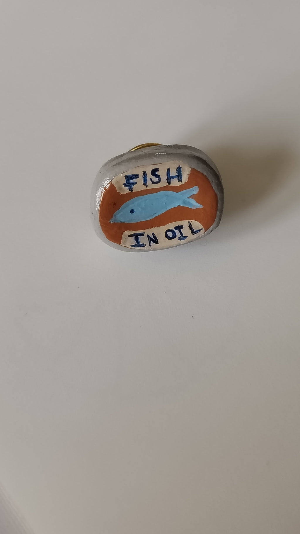 Decorative stone with a fish illustration and text on a plain background